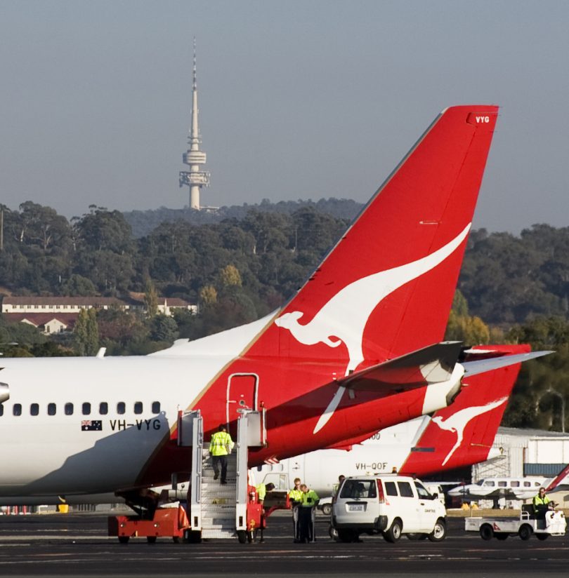 Qantas plane on tarmac at Canberra Airport, Telstra Tower in background.
