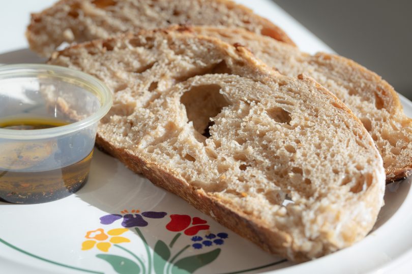Sliced sourdough bread and olive oil dip.