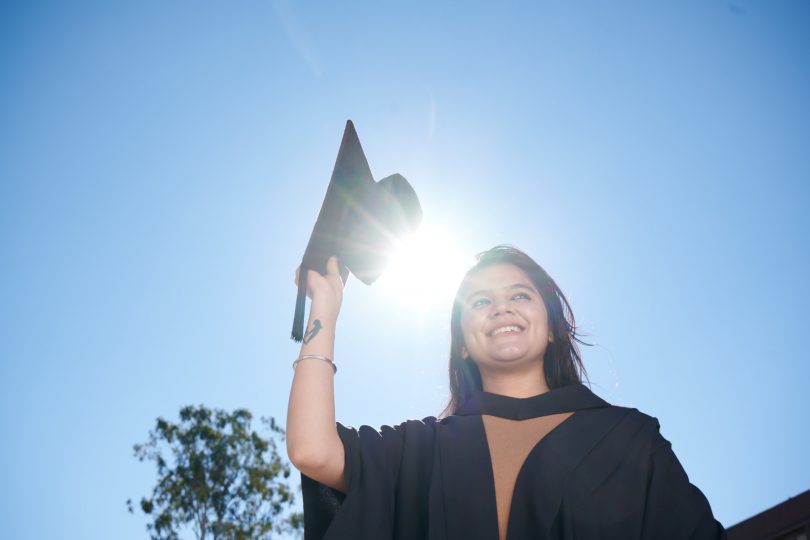 University of Canberra student with mortarboard and robe.