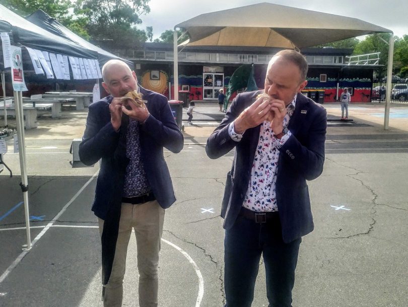 Andrew Barr and his partner Anthony Toms enjoy a democracy sausage at North Ainslie Primary School.