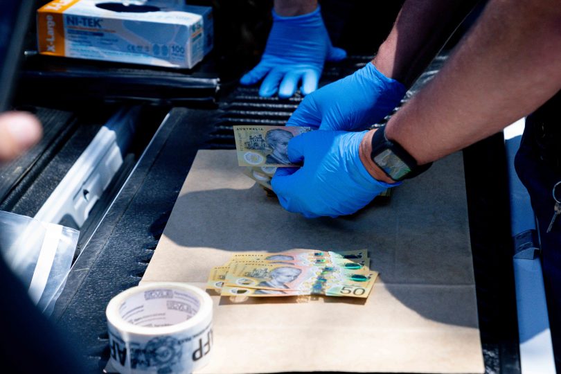 Police officer counting $50 notes