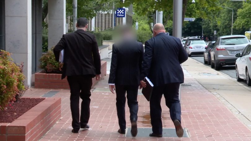 Criminal investigators from ACT Policing with one of the arrested men 