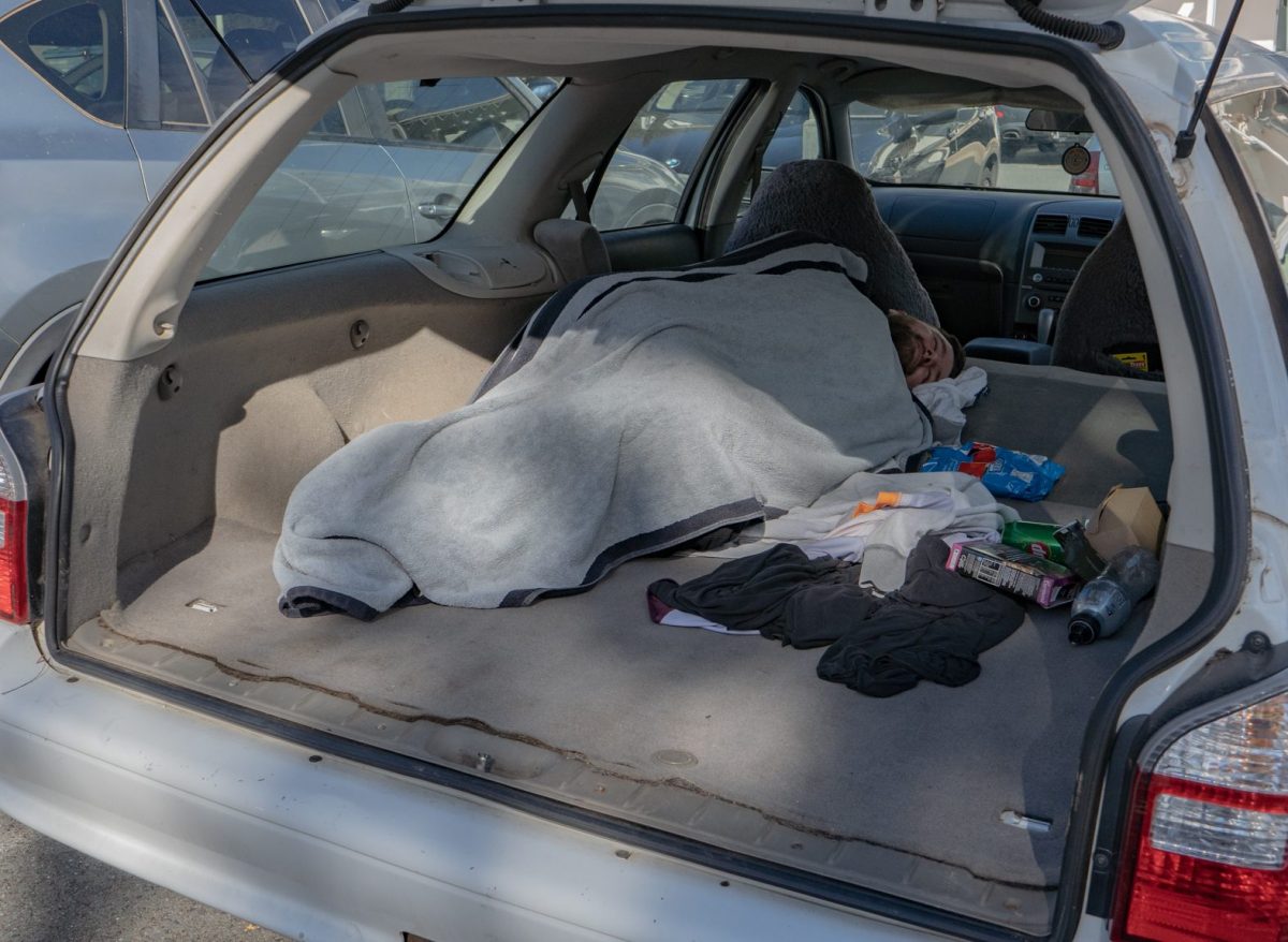 Homeless man sleeping in the back of car