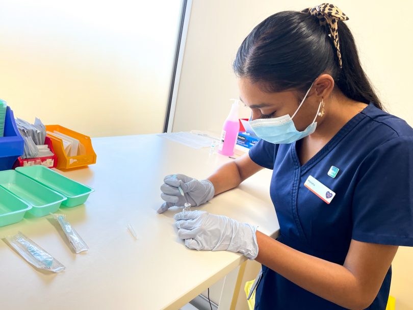 Nurse prepares vaccine at Calvary clinic