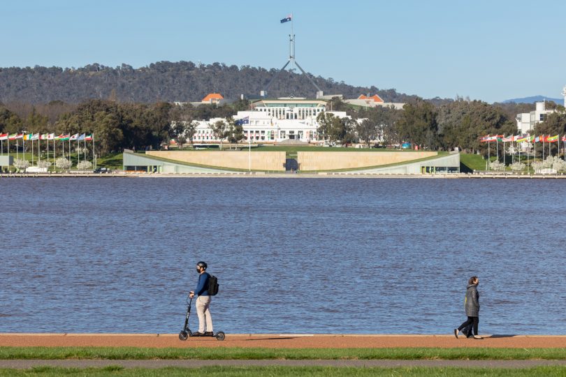 Man riding e-scooter at Lake Burley Griffin