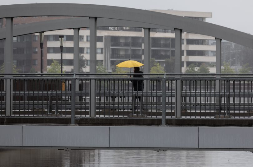Woman with yellow umbrella walking in the rain