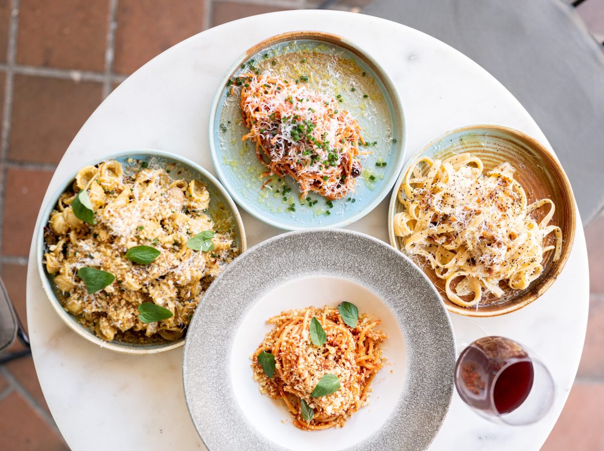 Four different pasta dishes on a table.