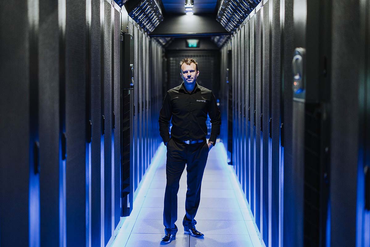 man standing in a room of computer servers
