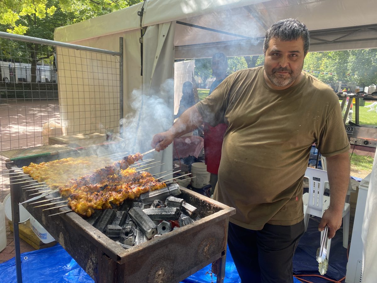 Man grilling skewers on smokey BBQ