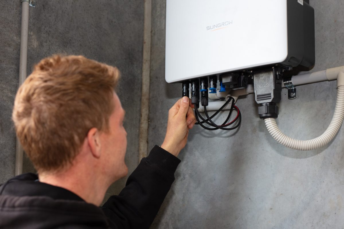 Worker plugs in a solar panel system.