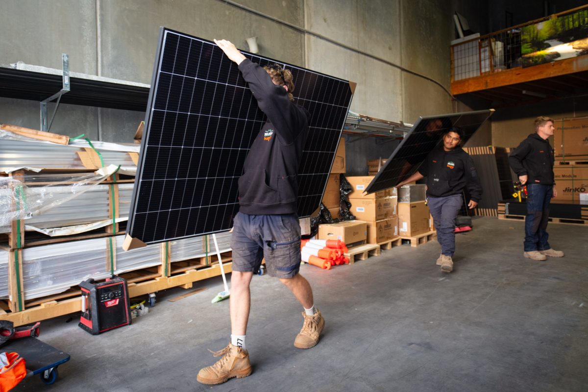 Men carrying solar panels