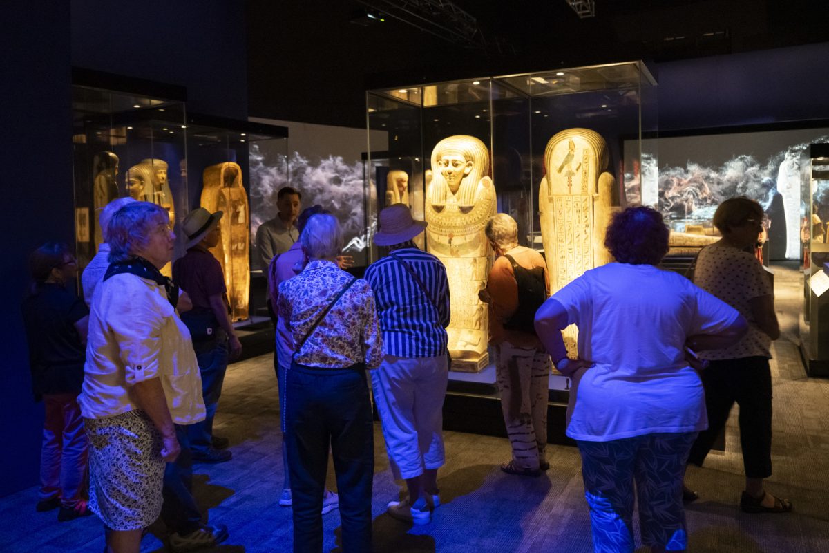 People looking at mummies in display cases