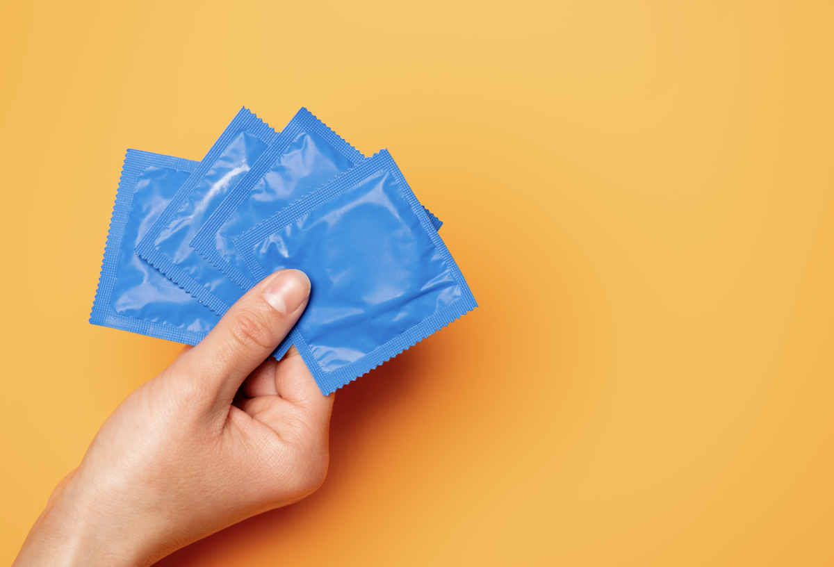 A hand holding small blue squares on orange background