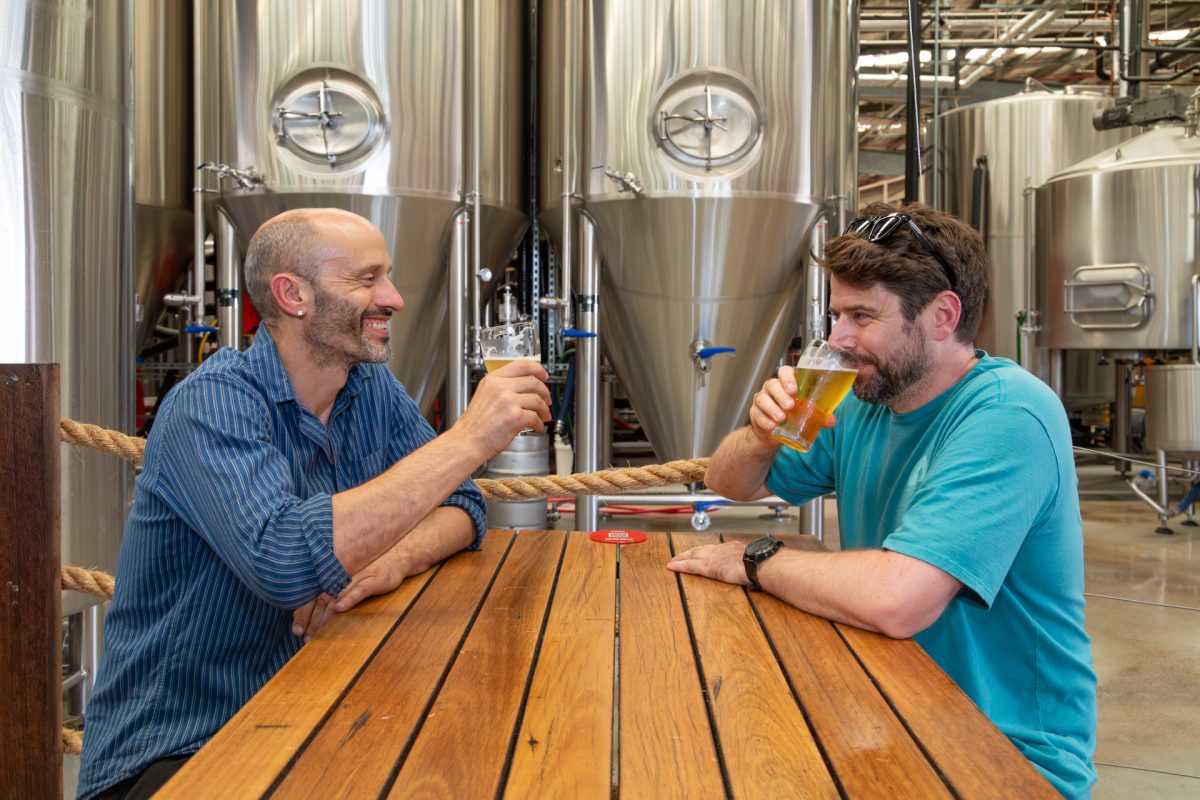 Two men sitting at a table and drinking beer