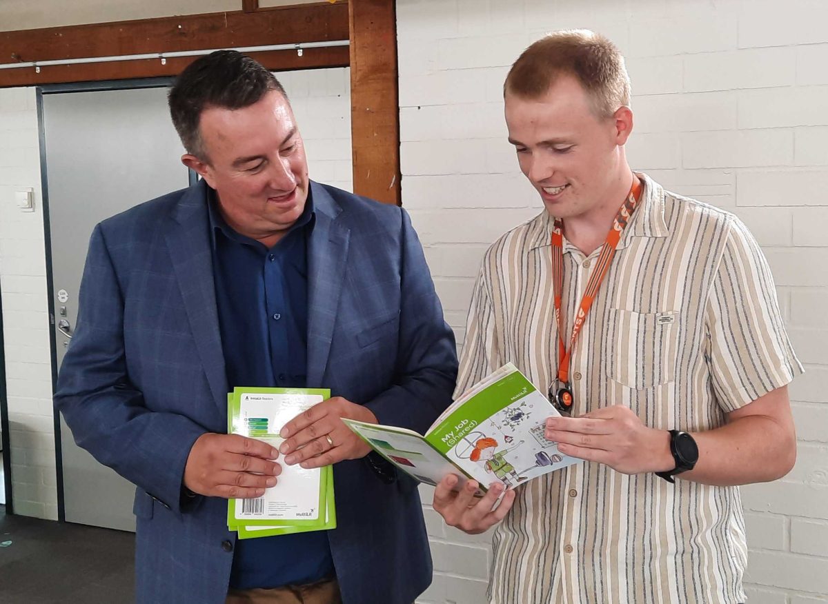 two men looking at a booklet