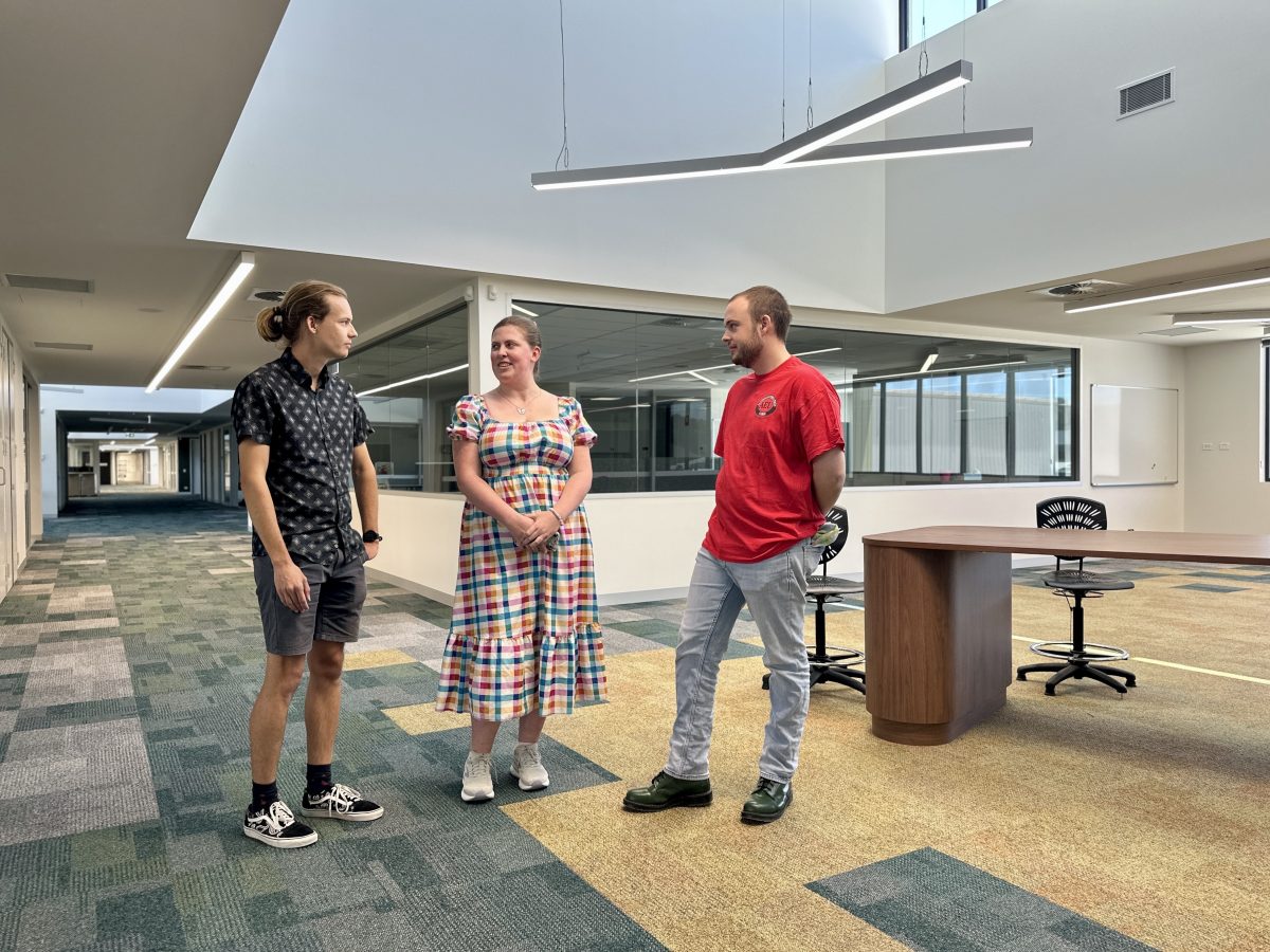 two men and a woman at a school