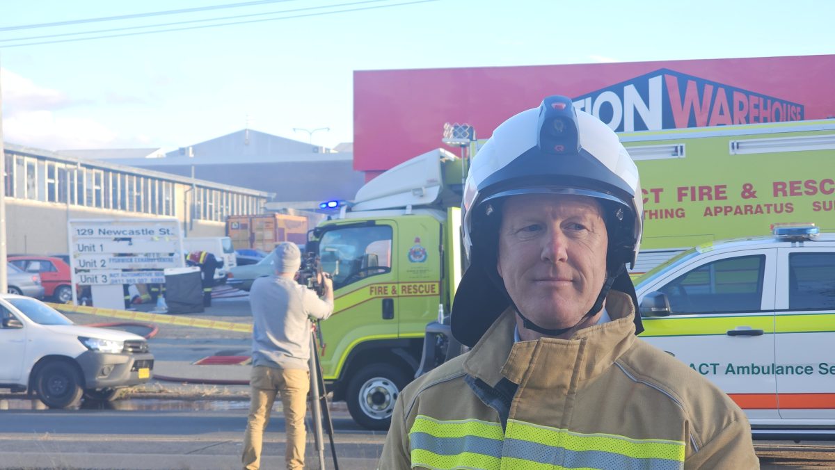 Paul Flynn Superintendent Fire and Rescue in front of fire fighting scene