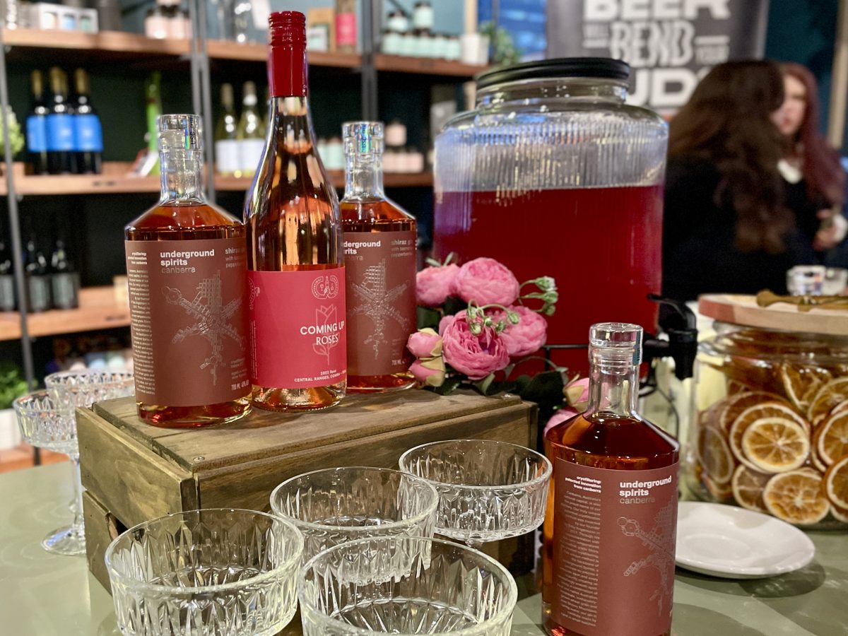A display with bottles of shiraz gin, rose wine and cocktail glasses.