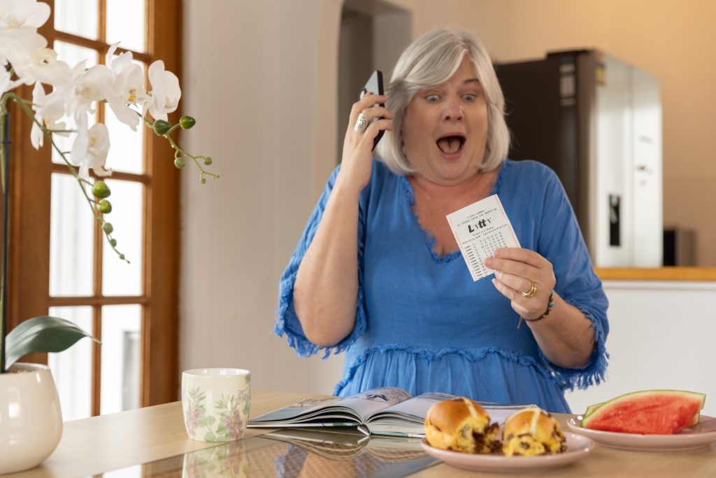 surprised woman holding a Lotto ticket