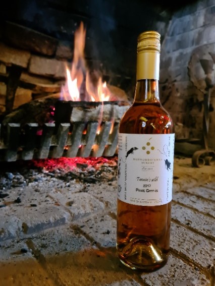 Bottle of wine from Murrumbateman Winery in front of fireplace.