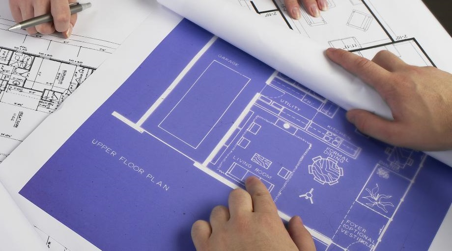 hands on a set of building plans